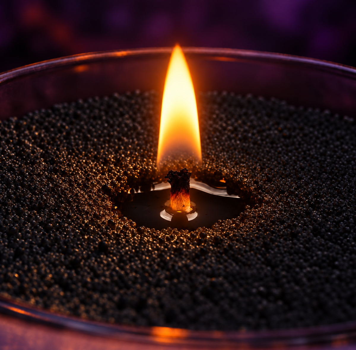 Close-up of a flame burning in black wax pearls