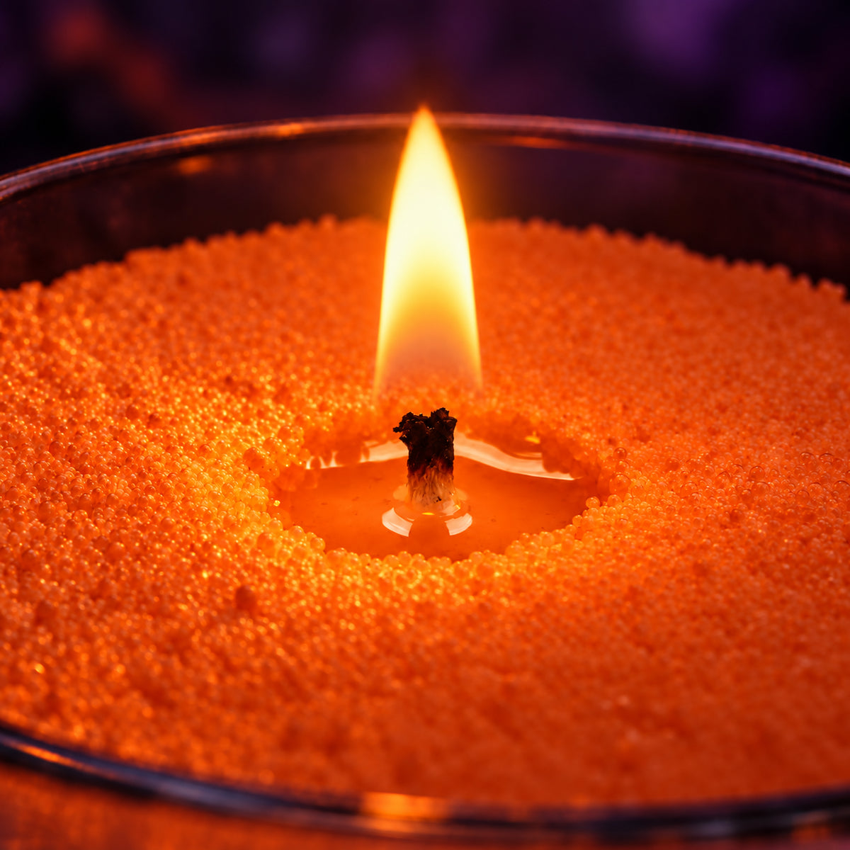 Close-up of a flame burning in orange wax pearls
