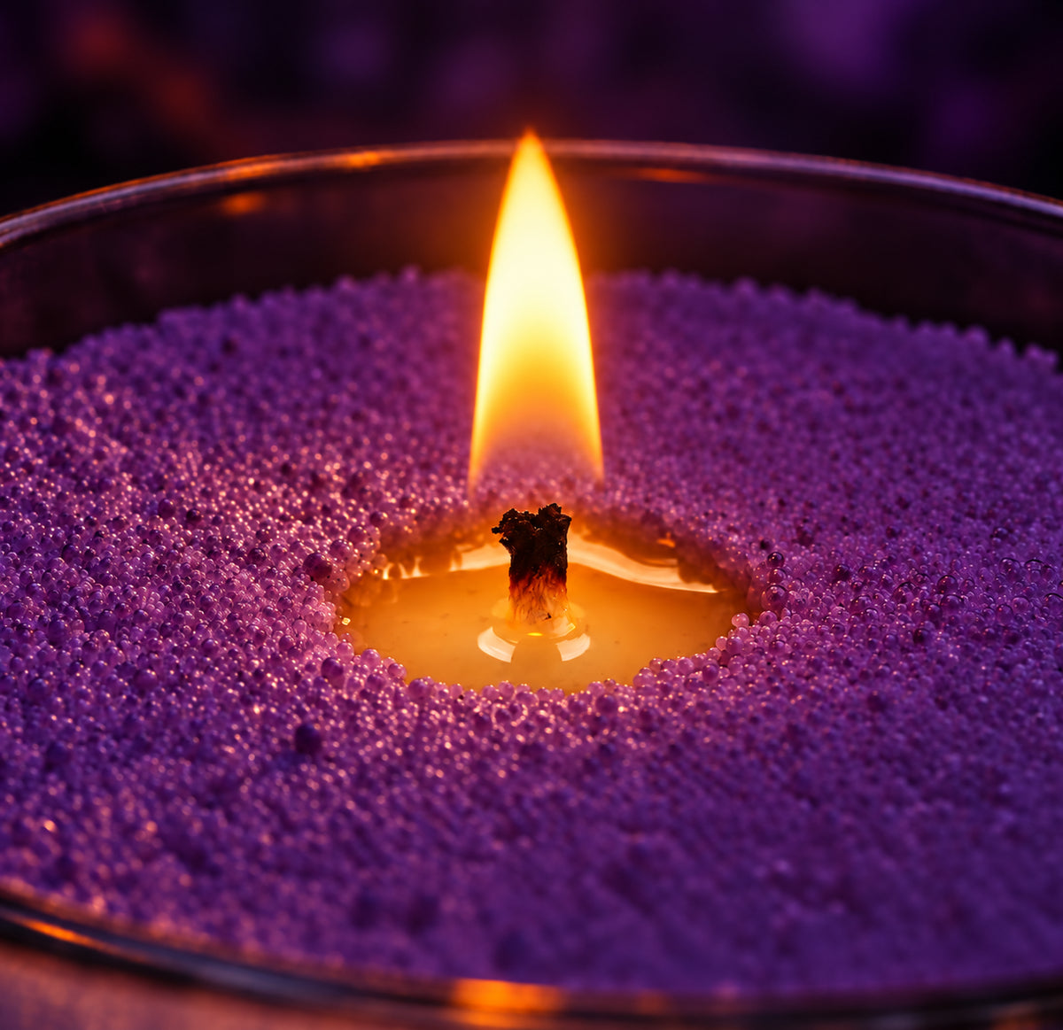Close-up of a flame burning in purple wax pearls